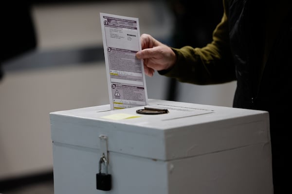 A man places his ballot in a box during early voting in Waukesha, Wis Tuesday, March 18, 2025. (AP Photo/Jeffrey Phelps)