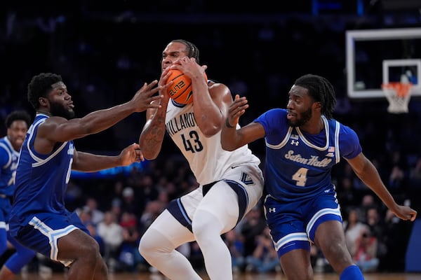 Seton Hall's Dylan Addae-Wusu, left, and Prince Aligbe, right, fights for control of the ball with Villanova's Eric Dixon, center, during the second half of an NCAA college basketball game at the Big East basketball tournament Wednesday, March 12, 2025, in New York. (AP Photo/Frank Franklin II)