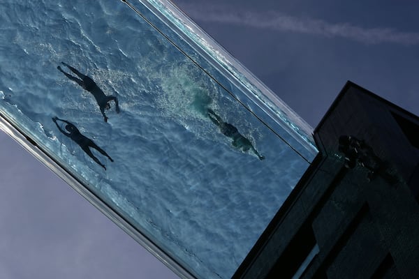 People swim in the Sky Pool on a sunny day in London, Thursday, May 1, 2025. (AP Photo/Kin Cheung)