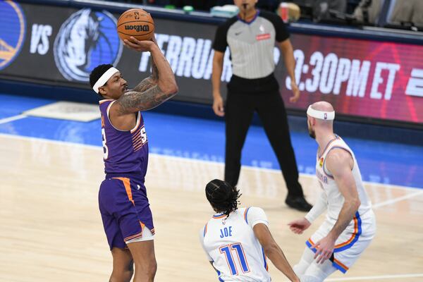 Phoenix Sun guard Bradley Beal, left, shoots near Oklahoma City Thunder guards Isaiah Joe, middle, and Alex Caruso, right, during the first half of an NBA basketball game, Wednesday, Feb. 5, 2025, in Oklahoma City. (AP Photo/Kyle Phillips)