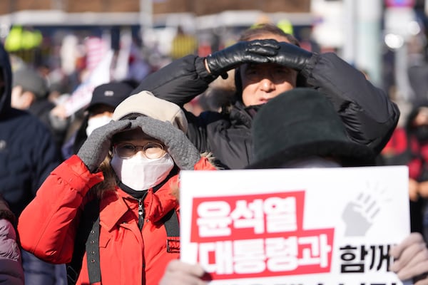 Supporter of impeached South Korean President Yoon Suk Yeol react during a rally to oppose his impeachment near the presidential residence in Seoul, South Korea, Wednesday, Jan. 15, 2025. The letters read "With President Yoon Suk Yeol." (AP Photo/Lee Jin-man)