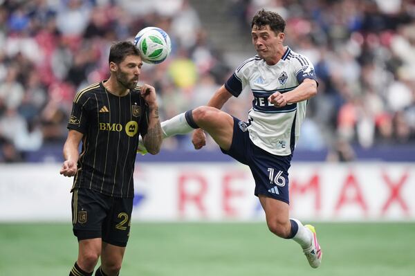Vancouver Whitecaps' Sebastian Berhalter, right, and Los Angeles FC's Ryan Hollingshead, left, vie for the ball during the second half of an MLS soccer match in Vancouver, British Columbia, Sunday, May 11, 2025. (Darryl Dyck/The Canadian Press via AP)