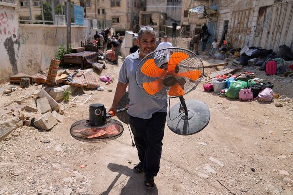 Residents of the now evacuated refugee camp of Tulkarem return to collect belongings before the destruction of their homes as Israeli forces prepare to carry out the demolition of 116 homes across the two refugee camps of the Israeli occupied West Bank city of Tulkarem, Friday, May 2, 2025. (AP Photo/Nasser Nasser)