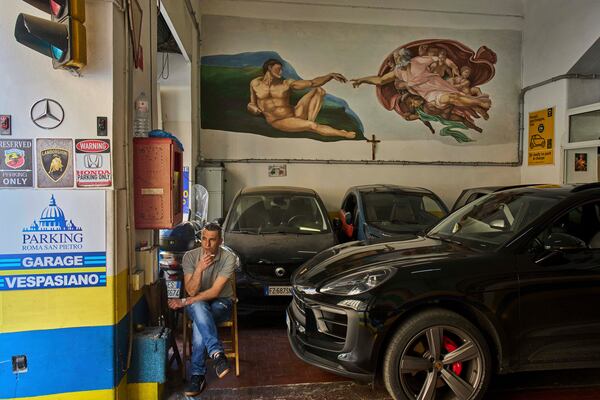 A reproduction of Michelangelo's "The Creation of Adam" is painted in a parking garage in Rome, Tuesday, May 6, 2025. (AP Photo/Bernat Armangue)