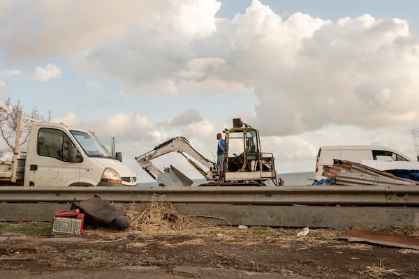 Construction crew clear debris from the area near Longoni port, Mayotte, Friday, Dec. 20, 2024. (AP Photo/Adrienne Surprenant)