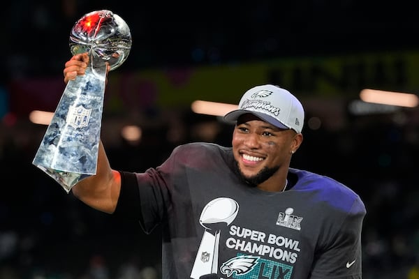 Philadelphia Eagles running back Saquon Barkley celebrates with the Vince Lombardi Trophy after the NFL Super Bowl 59 football game against the Kansas City Chiefs, Sunday, Feb. 9, 2025, in New Orleans. (AP Photo/Brynn Anderson)