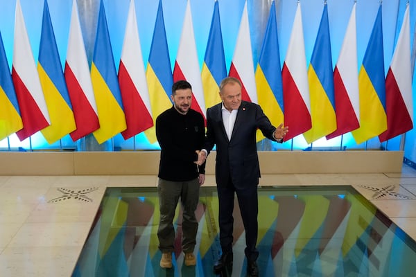 Polish Prime Minister Donald Tusk, right, welcomes Ukrainian President Volodymyr Zelenskyy after the two countries reached an agreement on a longstanding source of tensions between them: the exhumation of Polish victims of World War II-era massacres by Ukrainian nationalists, in Warsaw, Poland, on Wednesday, Jan. 15, 2025. (AP Photo/Czarek Sokolowski)