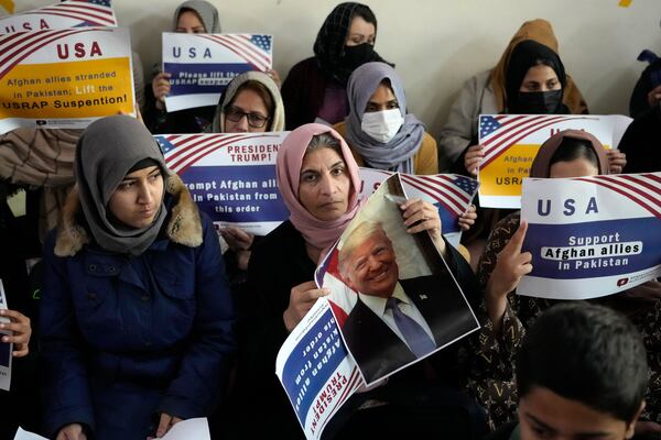 Afghan refugees hold placards during their meeting to discuss situation after President Donald Trump paused the U.S. refugee programs, in Islamabad, Pakistan, Friday, Jan. 24, 2025. (AP Photo/Anjum Naveed)