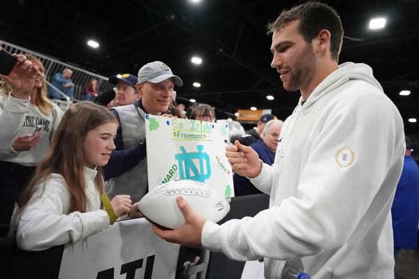 Notre Dame linebacker Jack Kiser signs autographs during media day ahead of the national championship NCAA College Football Playoff game between Ohio State and Notre Dame Saturday, Jan. 18, 2025, in Atlanta. The game will be played on Monday. (AP Photo/Brynn Anderson)