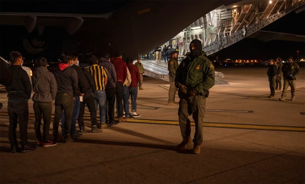 This photo provided by the U.S. Dept. of Defense, U.S. Customs and Border Protection Agents guide undocumented immigrants onboard a C-17 Globemaster III at the Tucson International Airport, Ariz., Thursday, Jan. 23, 2025. (Senior Airman Devlin Bishop/Dept. of Defense via AP)