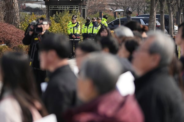 Police officers stand guard as protesters attend a press conference demanding to stop the upcoming Freedom Shield military exercise between the U.S. and South Korea and also demanding to investigate the cause thoroughly about fighter jets accidentally dropped eight bombs on a civilian area, in Seoul, South Korea, Friday, March 7, 2025. (AP Photo/Lee Jin-man)