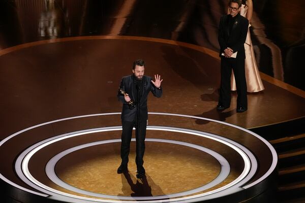 Kieran Culkin accepts the award for best performance by an actor in a supporting role for "A Real Pain" during the Oscars on Sunday, March 2, 2025, at the Dolby Theatre in Los Angeles. Robert Downey Jr. looks on from right. (AP Photo/Chris Pizzello)