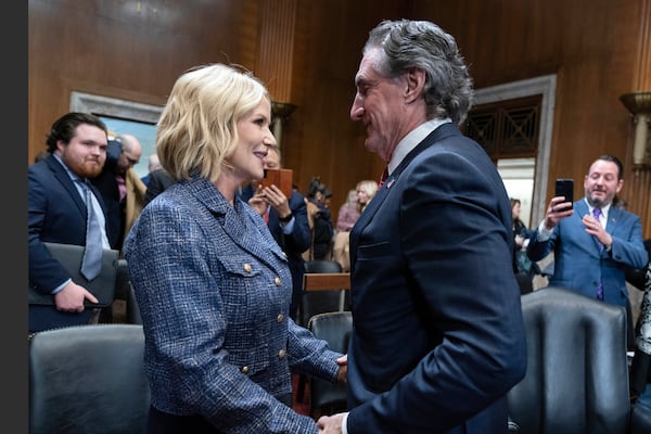 Former Gov. Doug Burgum, President-elect Donald Trump's choice to lead the Interior Department as Secretary of the Interior, speaks with his wife Kathryn Burgum at the end of a hearing of the Senate Energy and Natural Resources Committee on Capitol Hill in Washington, Thursday, Jan. 16, 2025. (AP Photo/Jose Luis Magana)