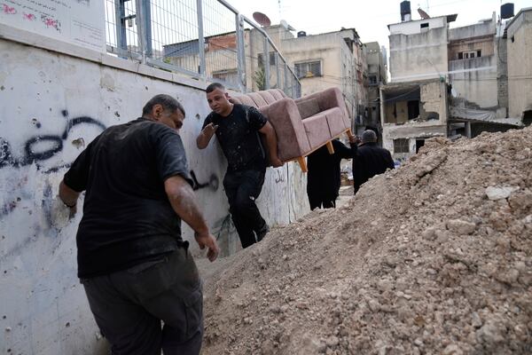 Residents of the now evacuated refugee camp of Tulkarem return to collect belongings before the destruction of their homes as Israeli forces prepare to carry out the demolition of 116 homes across the two refugee camps of the Israeli occupied West Bank city of Tulkarem, Friday, May 2, 2025. (AP Photo/Nasser Nasser)