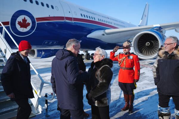 Canada Prime Minister Mark Carney, centre, is greeted by Commissioner of Nunavut Eva Aariak, right, as he and his wife Diana Fox Carney arrive in Iqaluit, Nunavut, on Tuesday, March 18, 2025. (Sean Kilpatrick/The Canadian Press via AP)