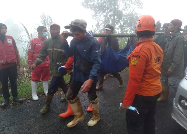 In this photo released by Indonesia's National Disaster Management Agency (BNPB), rescuers carry the body of a victim of flash flood in Pekalongan, Central Java, Indonesia on Tuesday, Jan. 21, 2025. (BNPB via AP)