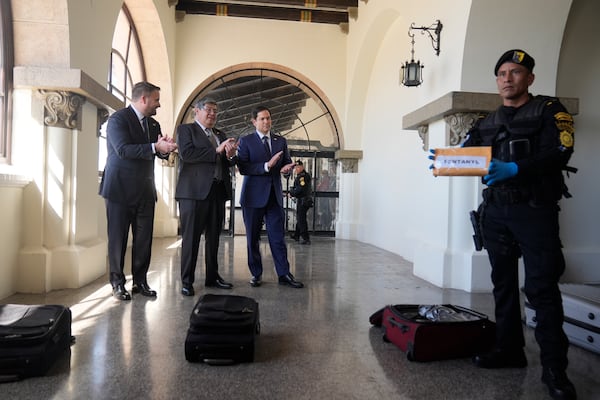 An agent holds up a packaged labeled fentanyl as U.S. Ambassador Tobin Bradley, from left, Guatemalan Interior Minister Francisco Jiménez, and U.S. Secretary of State Marco Rubio, watch a simulation of a sniffer dog trained to find narcotics, at La Aurora International Airport in Guatemala City, Wednesday, Feb. 5, 2025. (AP Photo/Mark Schiefelbein, Pool)