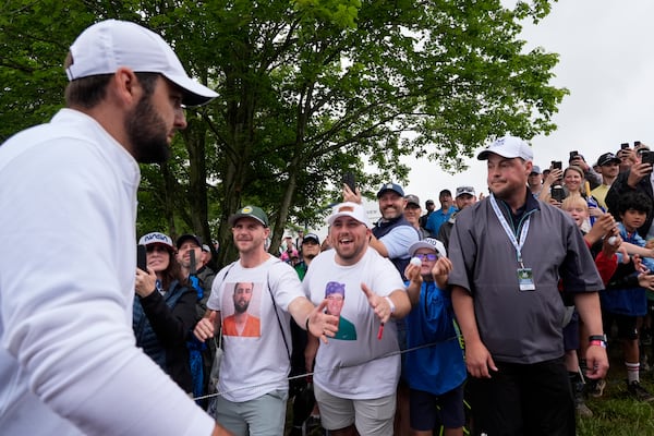 FILE - Scottie Scheffler is greeted by fans wearing T-shirts with Scheffler's booking photo after the second round of the PGA Championship golf tournament at the Valhalla Golf Club, Friday, May 17, 2024, in Louisville, Ky. (AP Photo/Matt York, File)