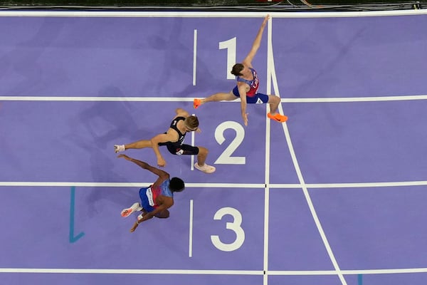 FILE - Cole Hocker, of the United States, top, celebrates after setting a new Olympic record winning the men's 1,500-meter final at the 2024 Summer Olympics, Tuesday, Aug. 6, 2024, in Saint-Denis, France. (AP Photo/David J. Phillip, File)