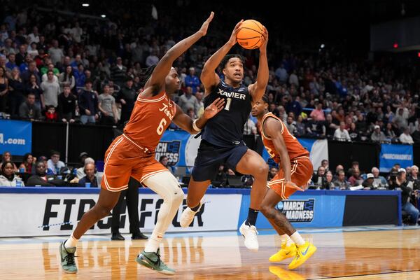 Xavier guard Marcus Foster (1) drives against Texas forward Arthur Kaluma (6) during the second half of a First Four college basketball game in the NCAA Tournament, Wednesday, March 19, 2025, in Dayton, Ohio. (AP Photo/Jeff Dean)