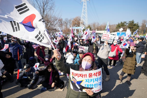 Supporters of impeached South Korean President Yoon Suk Yeol shout slogans during a rally to oppose his impeachment outside of a detention center in Uiwang, South Korea, Friday, Jan. 17, 2025. The letters read "Let's protect! Yoon Suk Yeol." (AP Photo/Lee Jin-man)