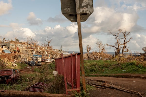 Containers, cars and debris litter the area near Longoni port, Mayotte, Friday, Dec. 20, 2024. (AP Photo/Adrienne Surprenant)