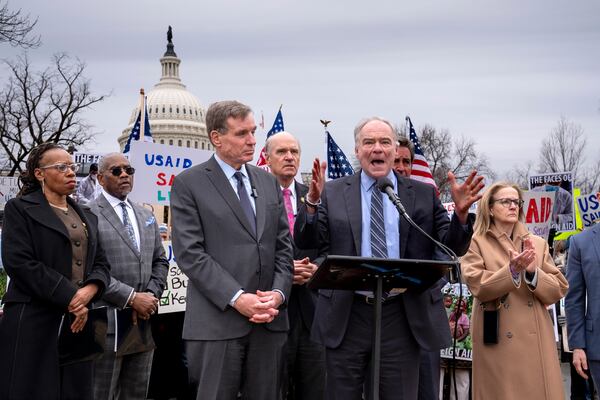 Demonstrators and lawmakers, including Sen. Mark Warner, D-Va., left, and Sen. Tim Kaine, D-Va., rally against President Donald Trump and his ally Elon Musk as they disrupt the federal government, including dismantling the U.S. Agency for International Development, which administers foreign aid approved by Congress, on Capitol Hill in Washington, Wednesday, Feb. 5, 2025. (AP Photo/J. Scott Applewhite)