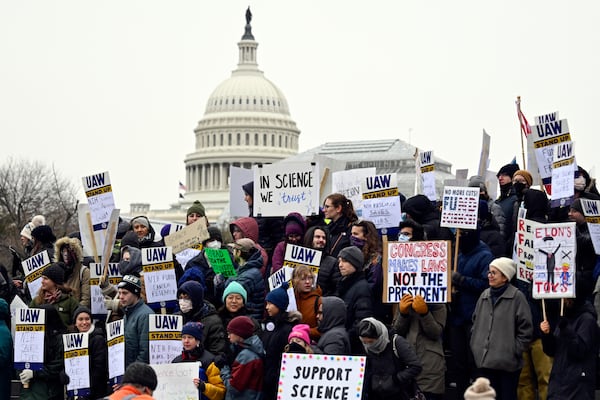 FILE - Medical researchers from universities and the National Institutes of Health rally near the Health and Human Services headquarters to protest federal budget cuts Wednesday, Feb. 19, 2025, in Washington. (AP Photo/John McDonnell, File)