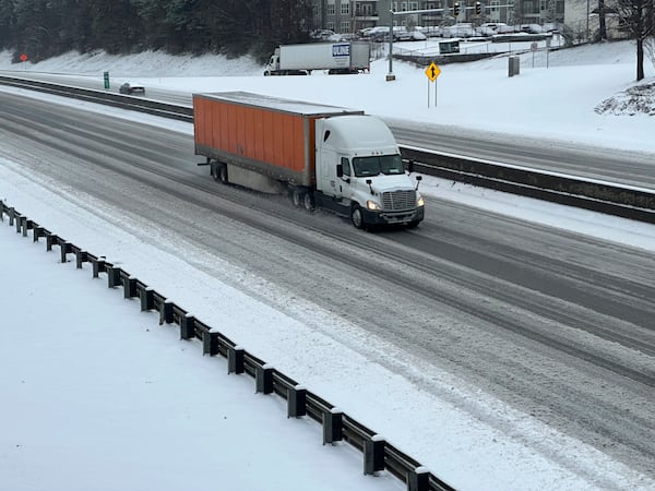 A truck picks its way along a slushy Interstate 285 northeast of downtown in Atlanta on Friday, Jan. 10, 2025. (AP Photo/Jeff Amy)