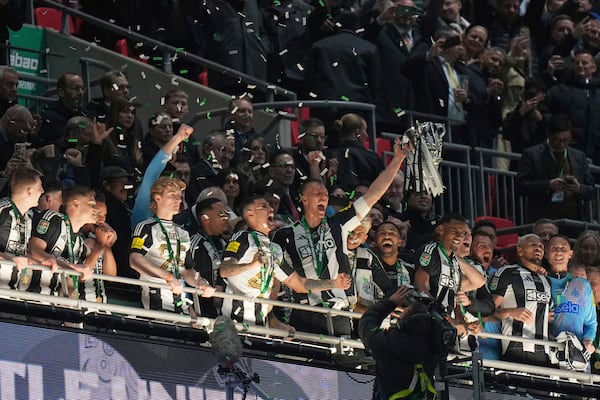 Newcastle United players celebrate with the trophy after winning the EFL Cup final soccer match between Liverpool and Newcastle at Wembley Stadium in London, Sunday, March 16, 2025. (AP Photo/Alastair Grant)