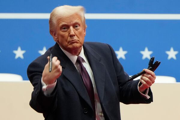 FILE - President Donald Trump throws pens used to sign executive orders to the crowd during an indoor Presidential Inauguration parade event in Washington, Jan. 20, 2025. (AP Photo/Matt Rourke, File)