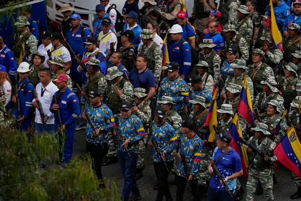 Government-backed militias pass through a street during a pro-government march in Caracas, Tuesday, Jan. 7, 2025, days ahead of President Nicolas Maduro's inauguration for a third term. (AP Photo/Matias Delacroix)