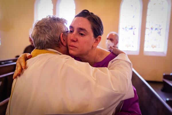 A congregant is hugged by a priest during a religious service in the aftermath of the Eaton Fire at Trinity Lutheran Church Sunday, Jan. 12, 2025 in Pasadena, Calif. (AP Photo/Ethan Swope)