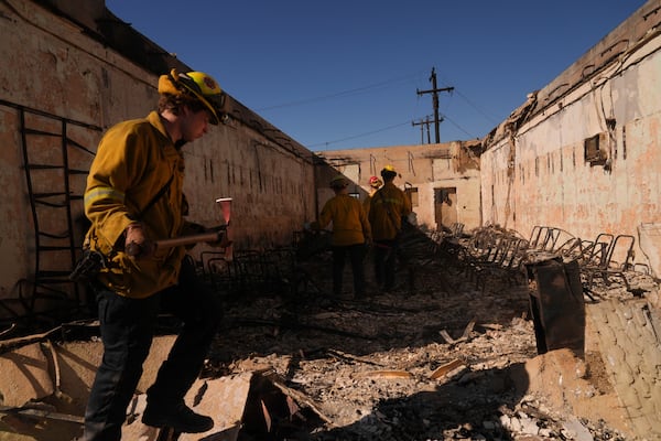 Search and rescue workers dig through the rubble left behind by the Eaton Fire, in Altadena, Calif., Tuesday, Jan. 14, 2025. (AP Photo/Jae C. Hong)