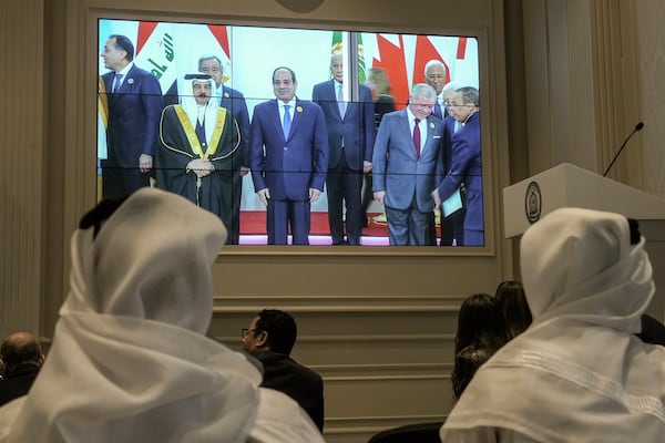 Journalists watch a screen displaying Egyptian President Abdel Fattah el-Sissi, center, with Arab Leaders, at the press center hall of the emergency Arab summit at Egypt's New Administrative Capital, just outside Cairo, Tuesday, March 4, 2025. (AP Photo/Amr Nabil)