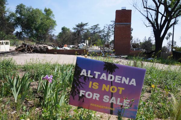 A sign reads "Altadena is not for sale" in front of a fire-damaged property in Altadena, Calif., Tuesday, April 22, 2025. (AP Photo/Damian Dovarganes)