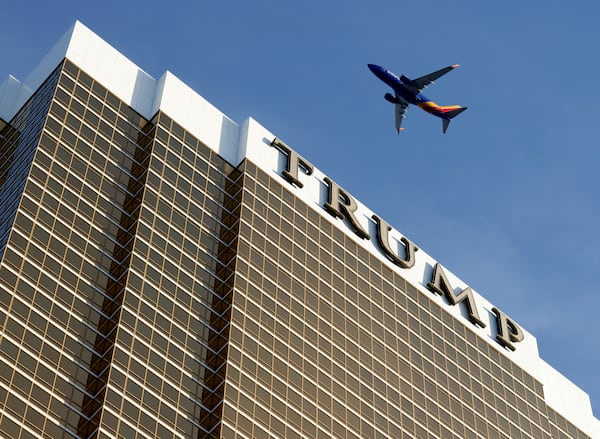 An airplane flies over Trump International Hotel, on Thursday, Jan. 2, 2025, in Las Vegas. (Bizuayehu Tesfaye/Las Vegas Review-Journal via AP)