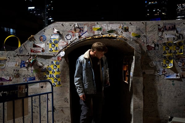 A young man leaves a replica of a tunnel used by Hamas militants during a rally to free the hostages held by Hamas in the Gaza Strip, in Tel Aviv, Israel, Tuesday, Jan. 14, 2025. (AP Photo/Maya Alleruzzo)