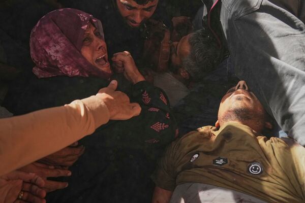 A woman reacts over the bodies of some of the victims of an Israeli army strike on a restaurant, which killed at least 29 people, as they are carried from the scene to a hospital in Gaza City, Wednesday, May 7, 2025.(AP Photo/Jehad Alshrafi)
