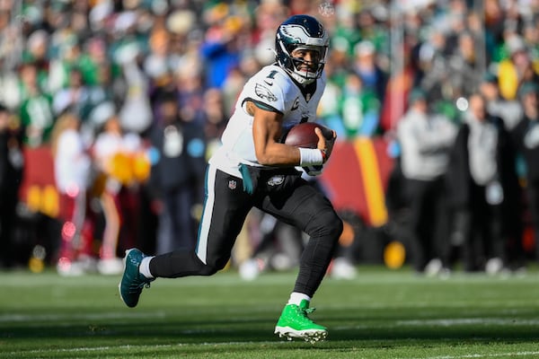 Philadelphia Eagles quarterback Jalen Hurts (1) running with the ball during the first half of an NFL football game against the Washington Commanders, Sunday, Dec. 22, 2024, in Landover, Md. (AP Photo/Nick Wass)