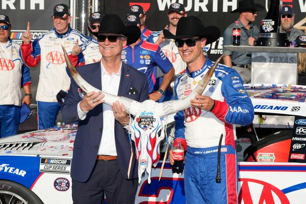 Joey Logano, right, poses with a cow skull Wurth 400 trophy in Victory Lane tafter winning a NASCAR Cup Series auto race at Texas Motor Speedway in Fort Worth, Texas, Sunday, May 4, 2025. (AP Photo/Gareth Patterson)