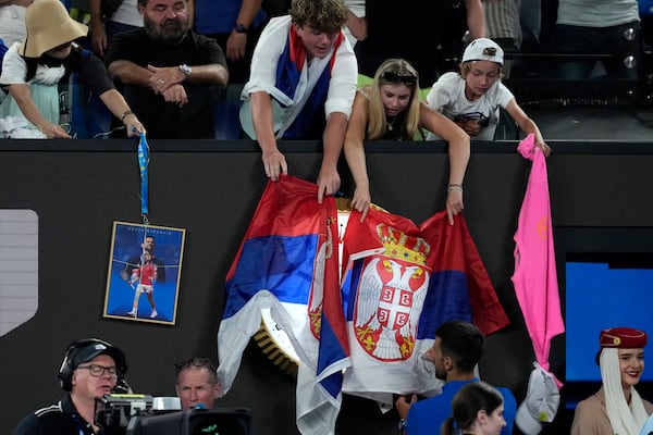 Novak Djokovic of Serbia autographs for fans after defeating Jiri Lehecka of the Czech Republic in a fourth round match at the Australian Open tennis championship in Melbourne, Australia, Sunday, Jan. 19, 2025. (AP Photo/Asanka Brendon Ratnayake)