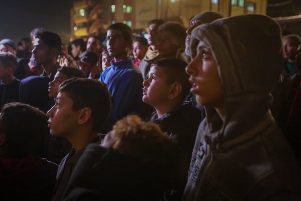 Palestinians watch TV as they await the imminent announcement of a ceasefire deal between Hamas and Israel in Khan Younis, central Gaza Strip, Wednesday, Jan. 15, 2025.(AP Photo/(AP Photo/Jehad Alshrafi)