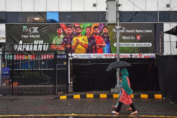 Girls walk past the Pindi Cricket Stadium, where a suspected Indian drone crashed in the parking area, in Rawalpindi, Pakistan, Thursday, May 8, 2025. (AP Photo/W.K. Youszai)