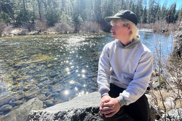 Aleksander Chmura, who was dismissed from his job as a park custodian, sits along a creek Thursday, Feb. 20, 2025, in Yosemite National Park, Calif. (AP Photo/Haven Daley)