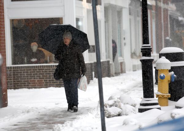 A person walks through the snow during a storm in Portsmouth, N.H., Thursday, Feb. 6, 2025. (AP Photo/Caleb Jones)