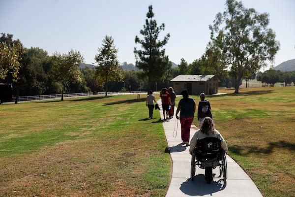 Attendees walk to board a tour bus during an accessible field trip to the San Andreas Fault organized by the International Association of Geoscience Diversity Thursday, Sept. 26, 2024, in San Bernadino, Calif. (AP Photo/Ryan Sun)