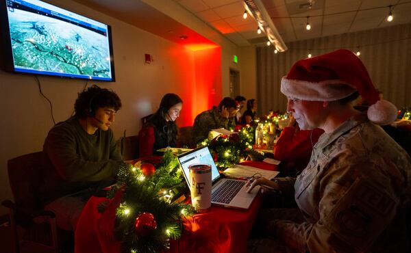 Air Force Col. Amy Glisson and other volunteers answer phone calls from around the world Tuesday, Dec. 24, 2024, at the NORAD Tracks Santa center at Peterson Space Force Base in Colorado Springs, Colo. (Christian Murdock /The Gazette via AP)