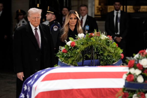 President-elect Donald Trump and Melania Trump pause at the flag-draped casket of former President Jimmy Carter as he lies in state in the rotunda of the U.S. Capitol in Washington, Wednesday, Jan. 8, 2025. (AP Photo/J. Scott Applewhite)