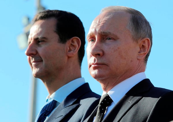 FILE - Russian President Vladimir Putin, right, and Syrian President Bashar Assad watch troops at the Hemeimeem air base in Syria, on Dec. 11, 2017. (Mikhail Klimentyev, Sputnik, Kremlin Pool Photo via AP, File)